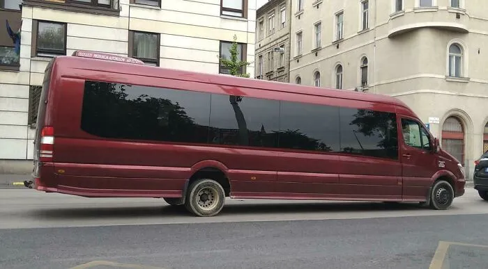 Extremely long red limousine van parked in the city, showing weird and wonderful vehicles.