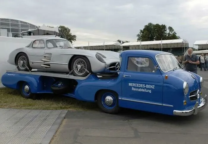 Classic blue Mercedes-Benz race car transporter carrying a silver sports car, one of wonderful vehicles.
