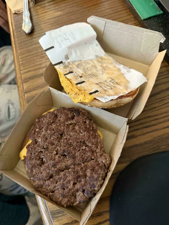 An open burger box with cheese stuck to the top lid, showing a cooking fail.