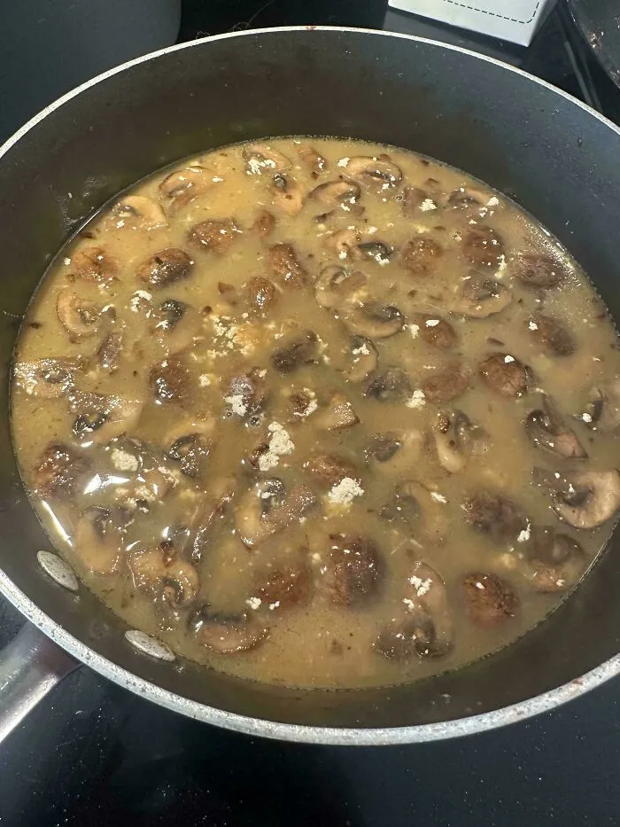 A pan of mushroom soup with unmixed white powder clumps as an example of things went wrong while cooking