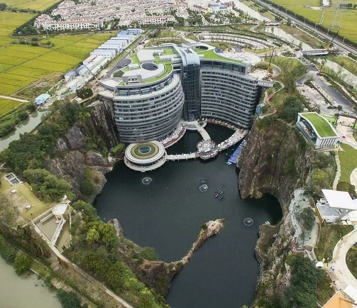 A luxury resort built into a deep quarry lake, showcasing bizarre shapes in its layout