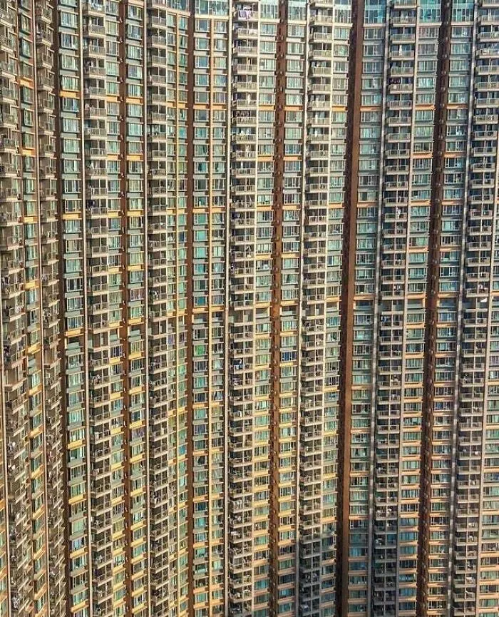 Towering residential high-rise with bizarre shapes and dense balconies filling the frame