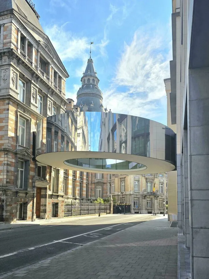 A reflective ring-shaped bridge between buildings, illustrating bizarre shapes in ordinary architecture