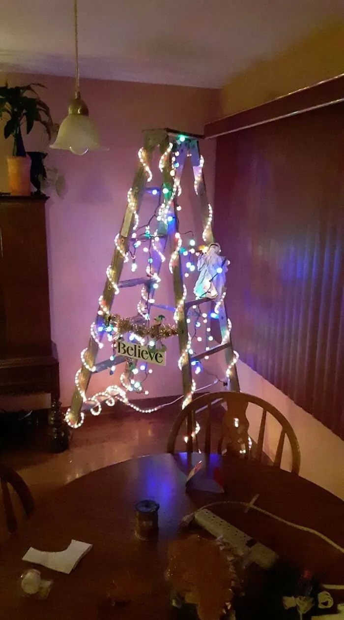 A creative DIY project of a wooden ladder decorated with shining colorful Christmas lights in a living room
