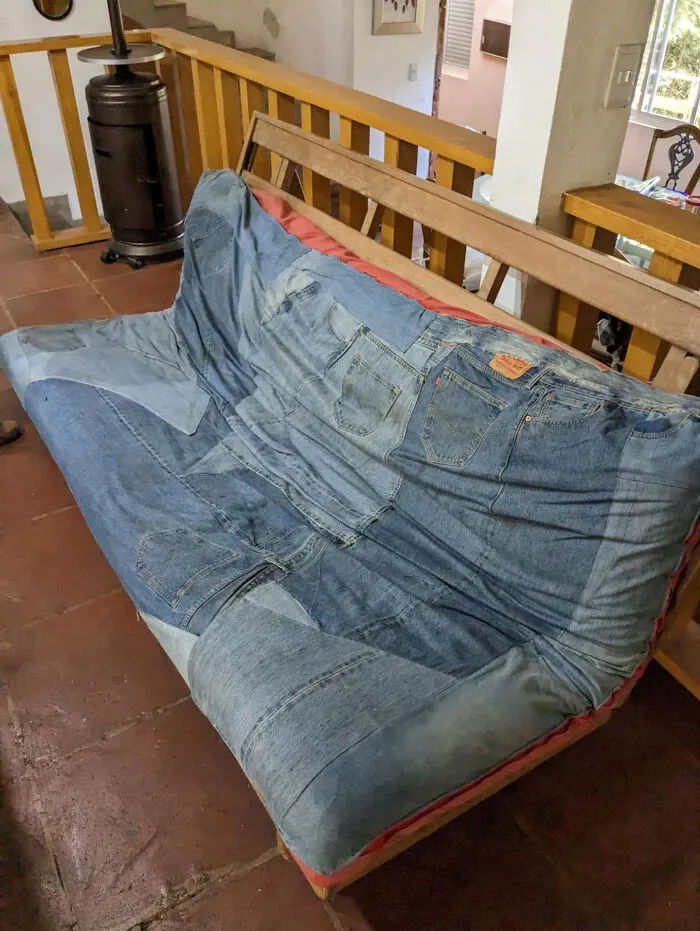An unusual DIY project featuring a futon sofa with a slipcover entirely made from denim jeans.