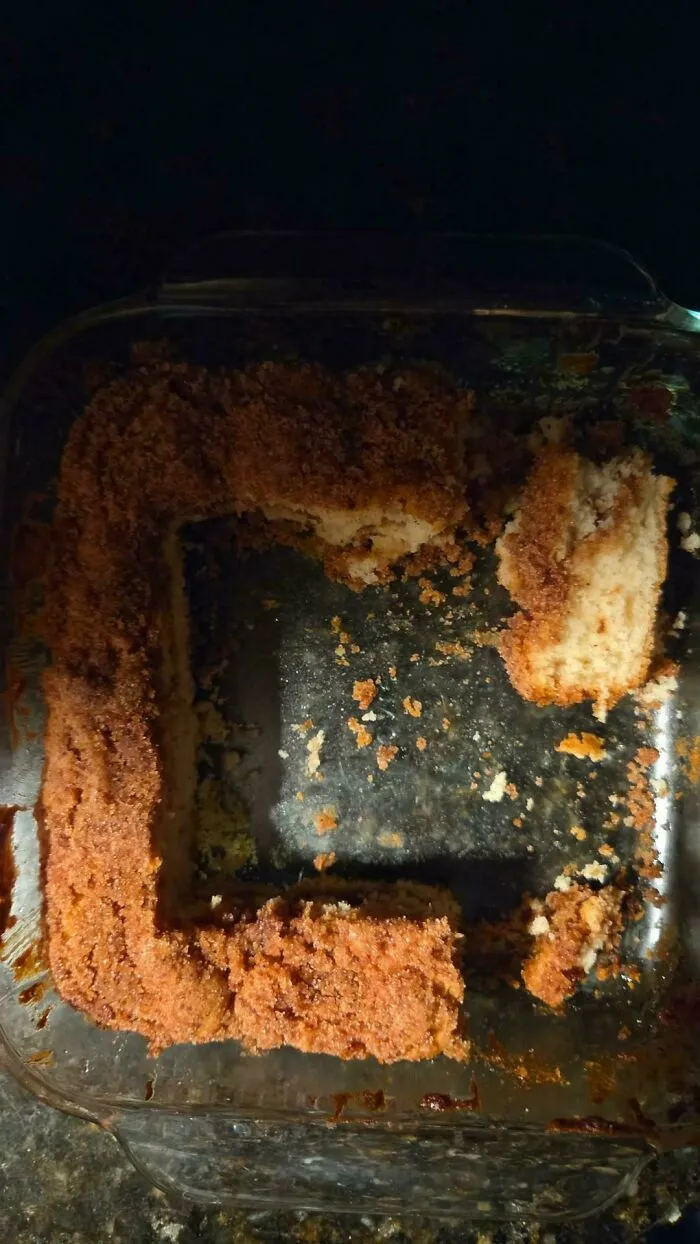 A square baking pan containing coffee cake with the middle sections awkwardly cut out.