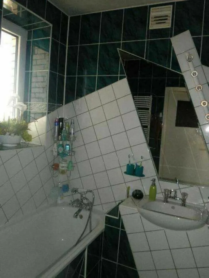 Quirky bathroom DIY projects with white tiles and a mirror placed at an unusual diagonal angle