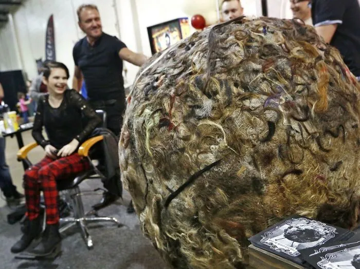 A massive ball of human hair sits on a table during a bizarre DIY project display.
