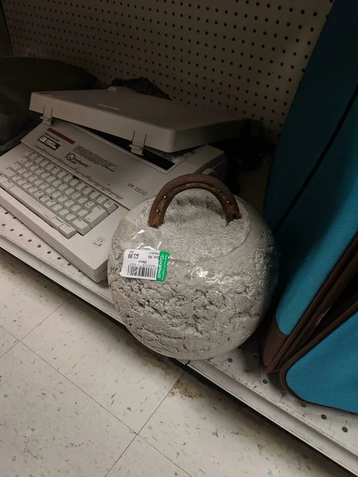 A round concrete weight with a metal handle as a rustic DIY project sitting on a shelf