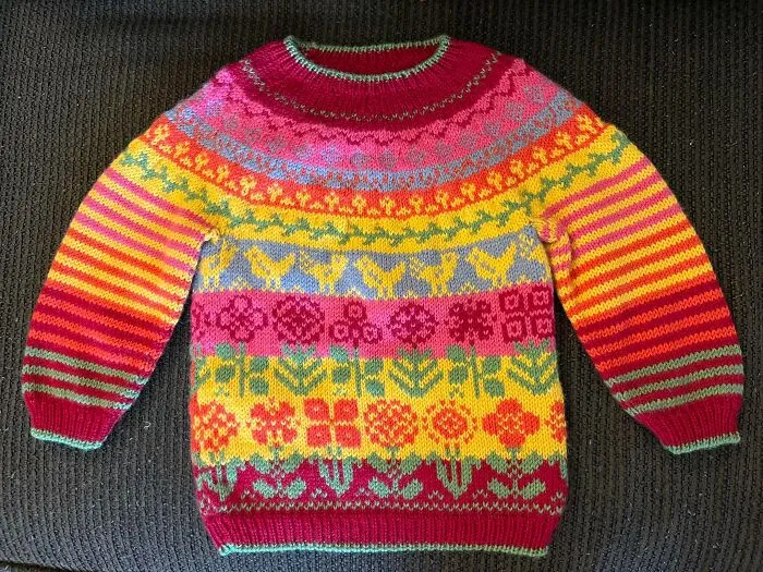A vibrant, colorful fair isle knitting sweater with flower and animal patterns
