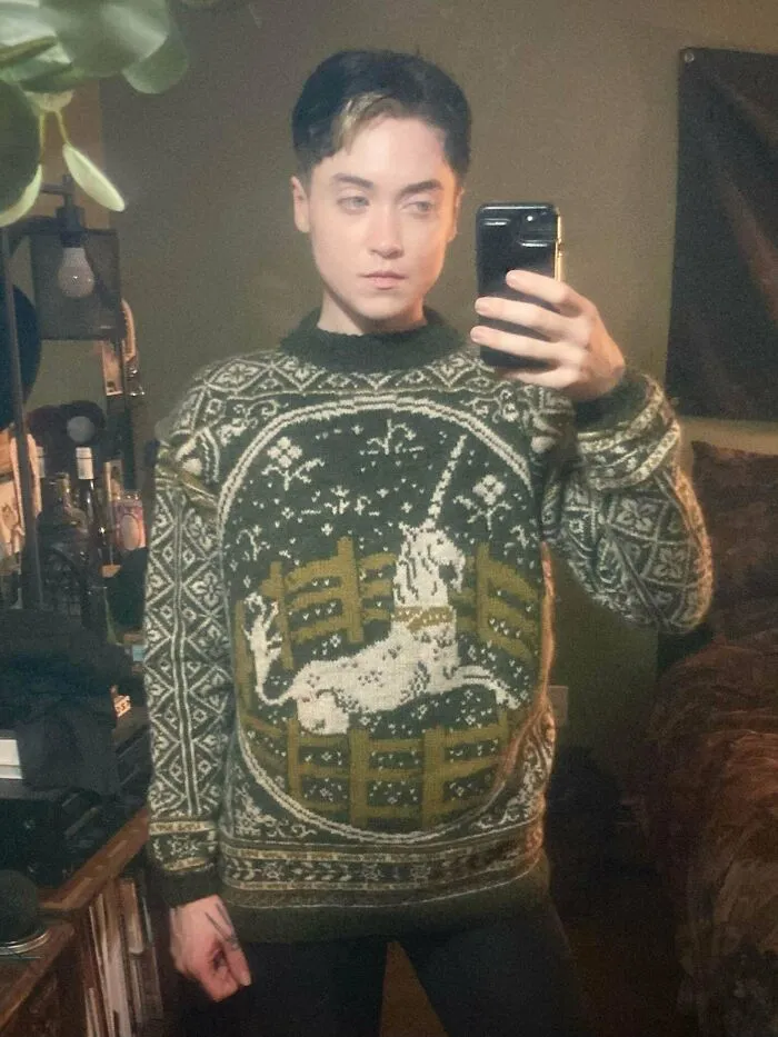 A creative knitting enthusiast wearing a hand-knit green and white unicorn sweater