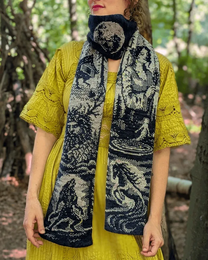 A detailed knitted scarf featuring forest animals and scenes made by knitting amateurs and pros