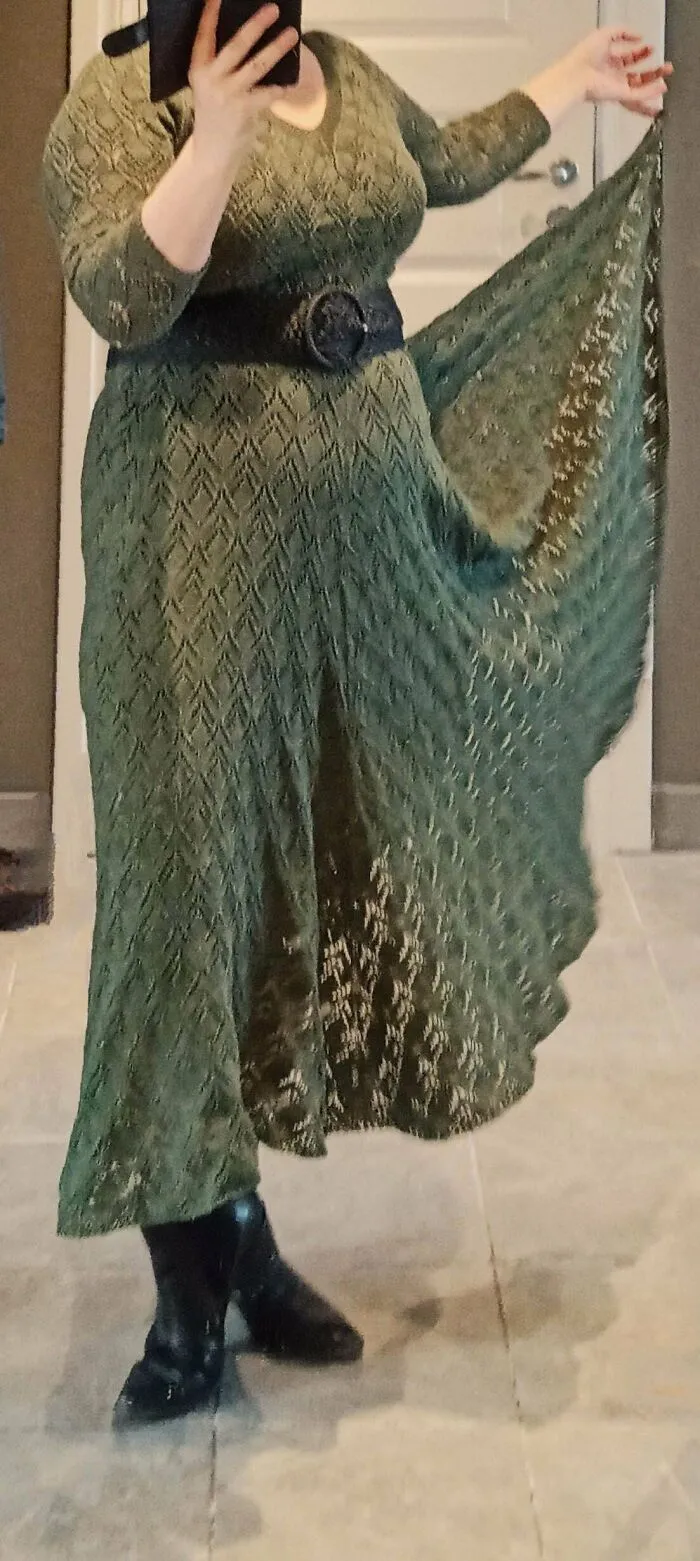 A woman wearing a beautiful green floor-length lace dress created by knitting amateurs and pros