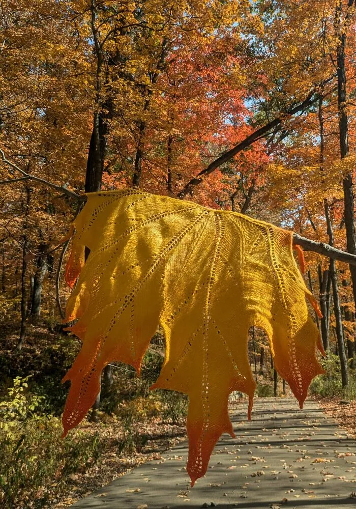 A large knitted leaf shawl in autumn colors reflecting creative knitting amateurs designs