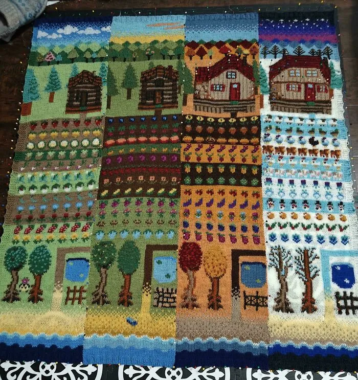 Four-panel knitted blanket depicting the four seasons with cabins, gardens, and changing trees.