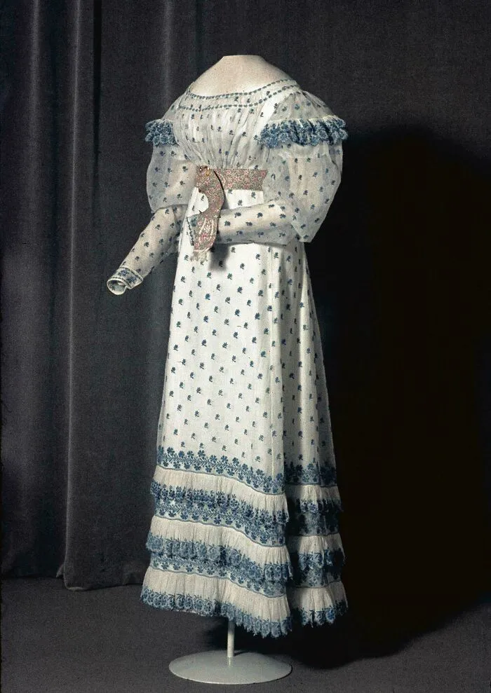 A white embroidered 1820s dress displayed as one of the historical treasures from 200 years ago.