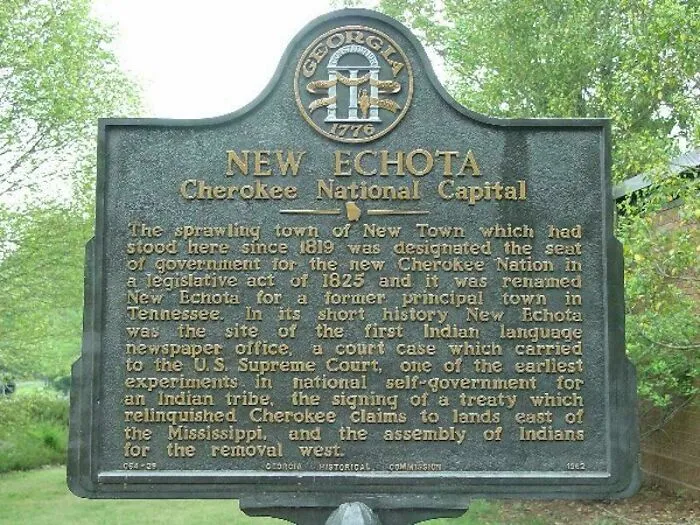 A bronze historical marker for New Echota Cherokee National Capital, among historical treasures from 200 years ago.