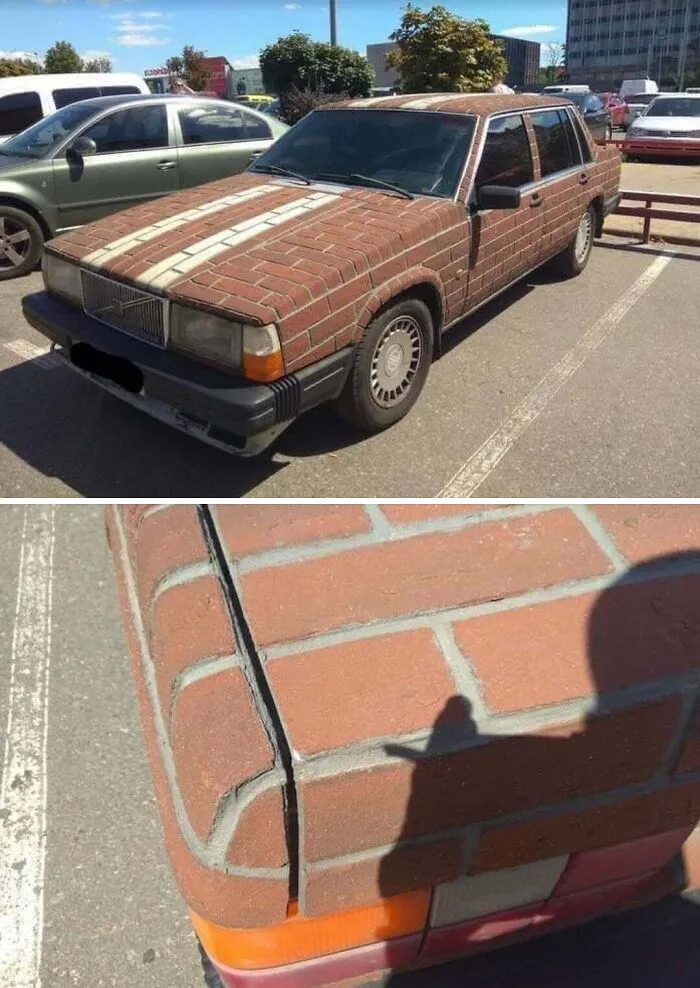 An unconventional DIY project car covered in realistic brick-patterned siding parked in a lot