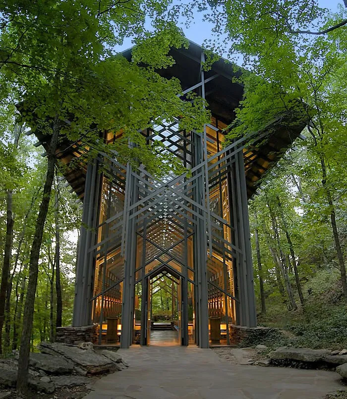 A glass chapel in a forest showcasing architecture with bizarre shapes.