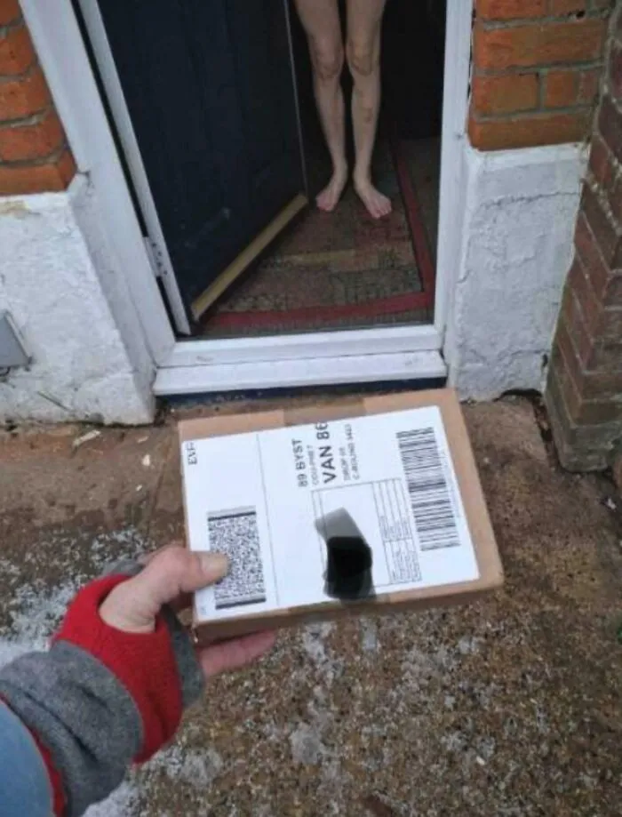 A delivery worker holding a package for a naked customer, showing things went wrong during delivery.