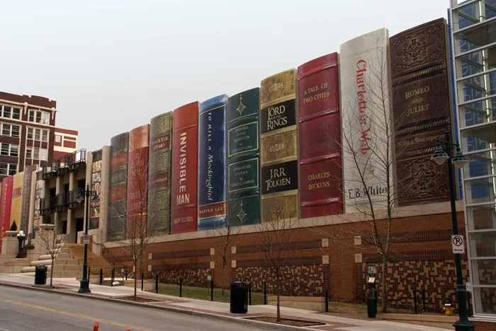 A building wall designed like giant colorful books displaying various literary titles