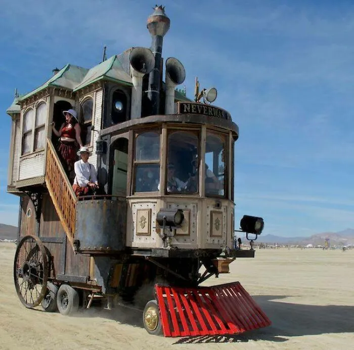 A bizarre steampunk vehicle styled like a building traveling across a desert landscape