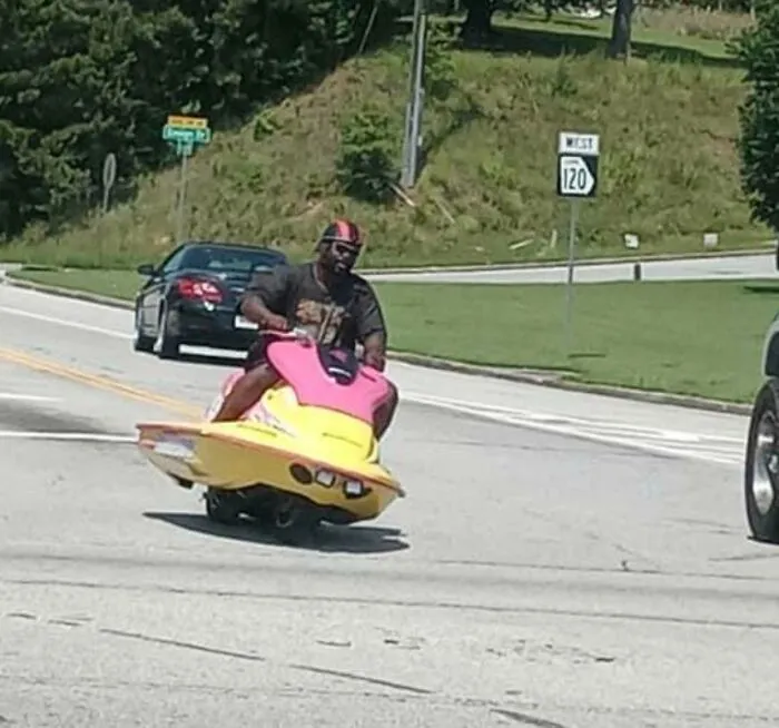 A man riding a jet ski modified as a road vehicle, one of the most wonderful vehicles on the street.