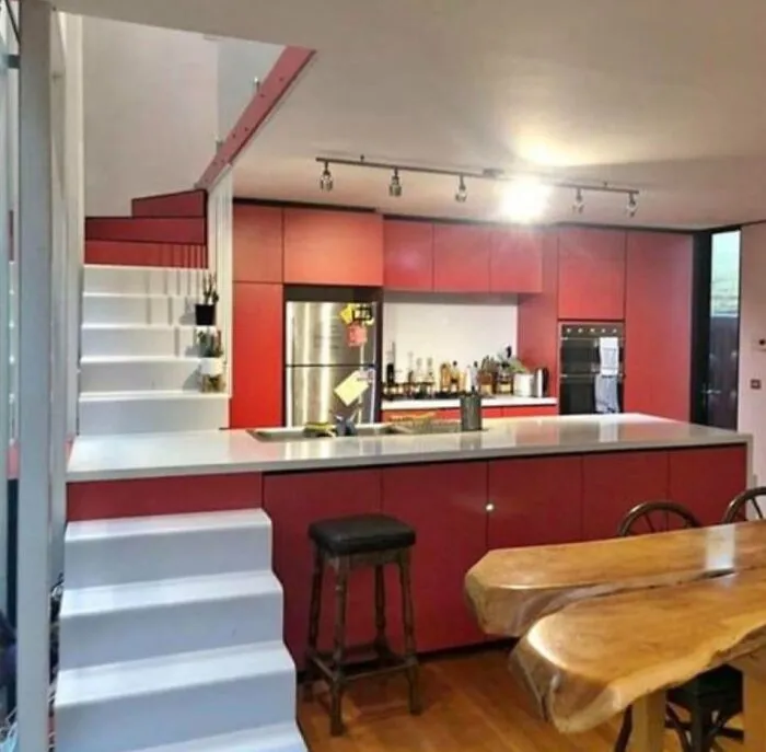 A kitchen island with steps leading directly to a staircase landing, illustrating an odd DIY project