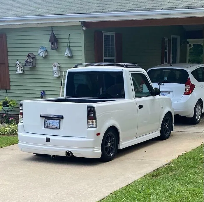 Custom white compact pickup truck in a driveway, featured among weird vehicles.