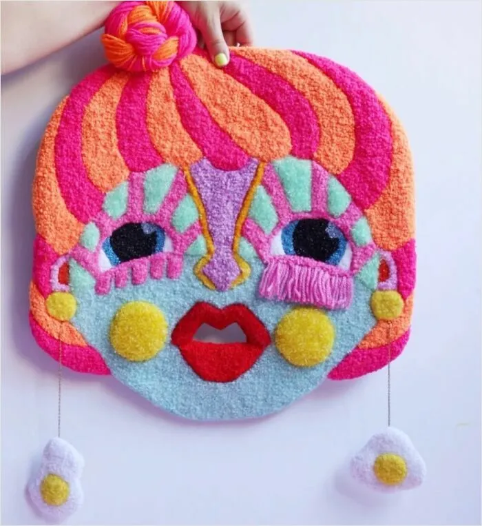 Colorful doll face tufted rug with fried egg earrings created by Ina Dyreborg.