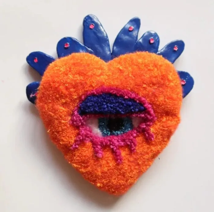 Orange tufted heart with eye and blue ceramic crown by Ina Dyreborg