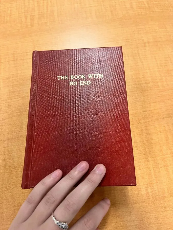 Hand holding a red book titled The Book With No End, part of creepy mysteries from around the web