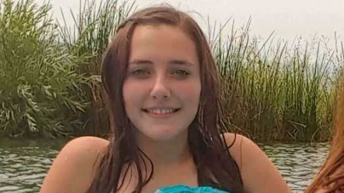 A young woman outdoors smiling, related to unsolved creepy mysteries from around the web.