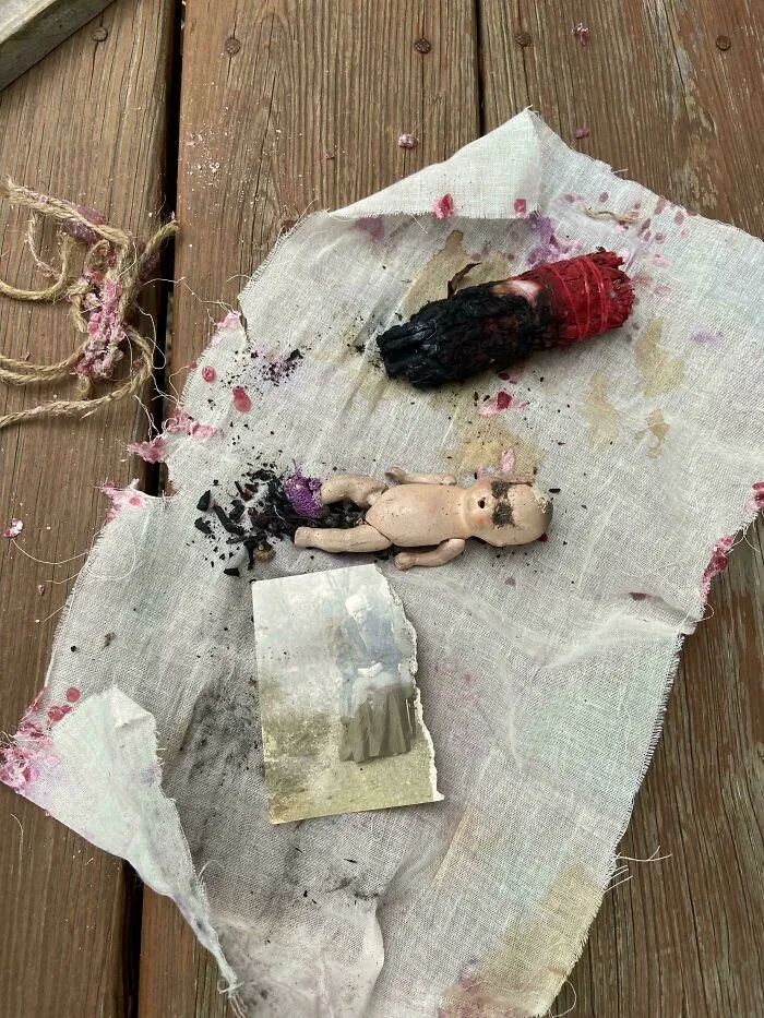 A small doll, old photo, and smudged sage on cloth, showing creepy mysteries from around the web.