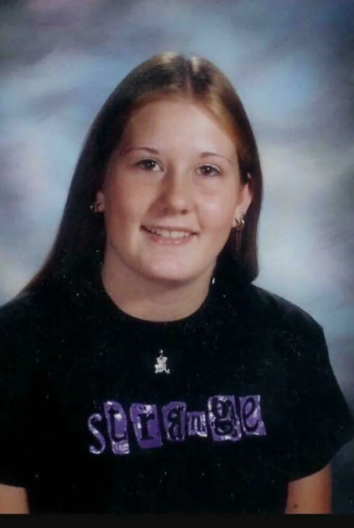 Portrait of a young woman wearing a black shirt that says strange, from creepy mysteries online.