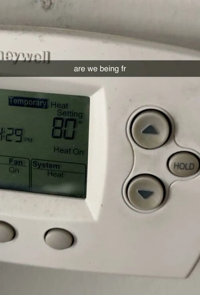 A household thermostat set to a high temperature of 80 degrees, highlighting roommate stories about energy bills.