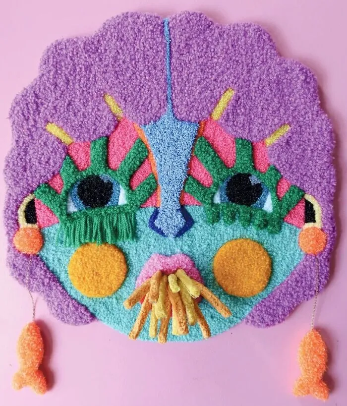 Whimsical tufted face portrait with tassels by Ina Dyreborg