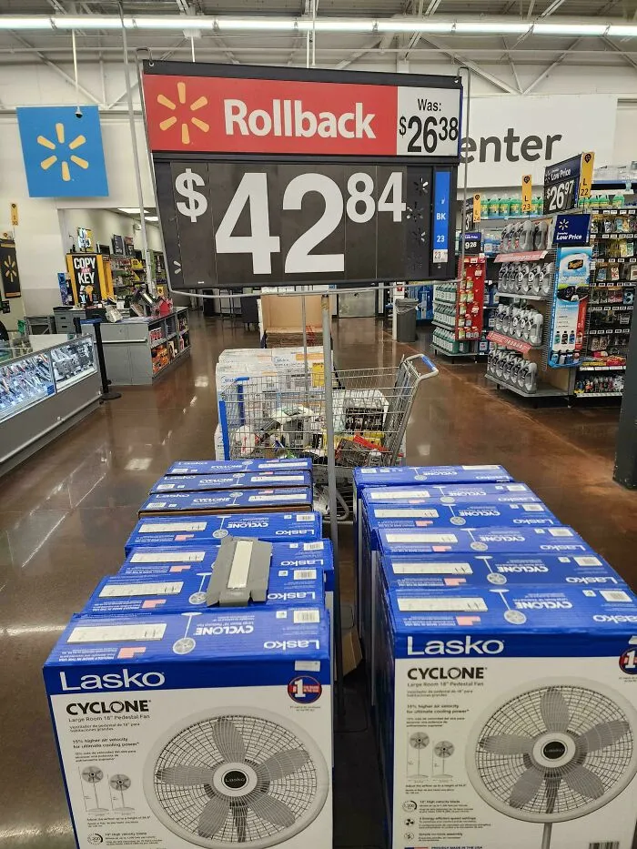 A Lasko fan price sign at Walmart displaying a Rollback price higher than the original, in modern life in America.