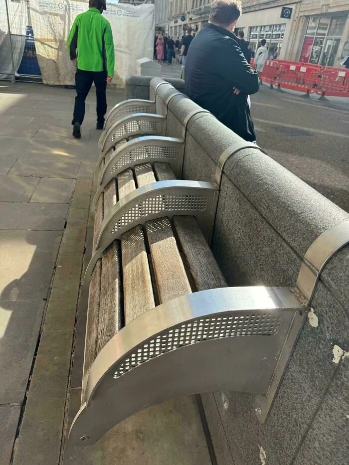 An uncomfortable bench designed to discourage lying down, highlighting aspects of modern life in America.