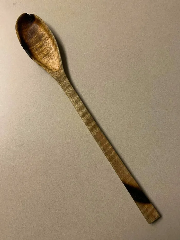 Burnt wooden spoon on a grey surface showing bad roommate stories