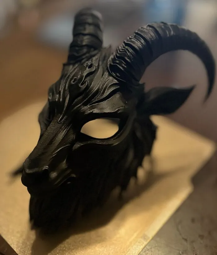 A detailed black goat-headed mask featuring large horns, showcasing creative 3D prints