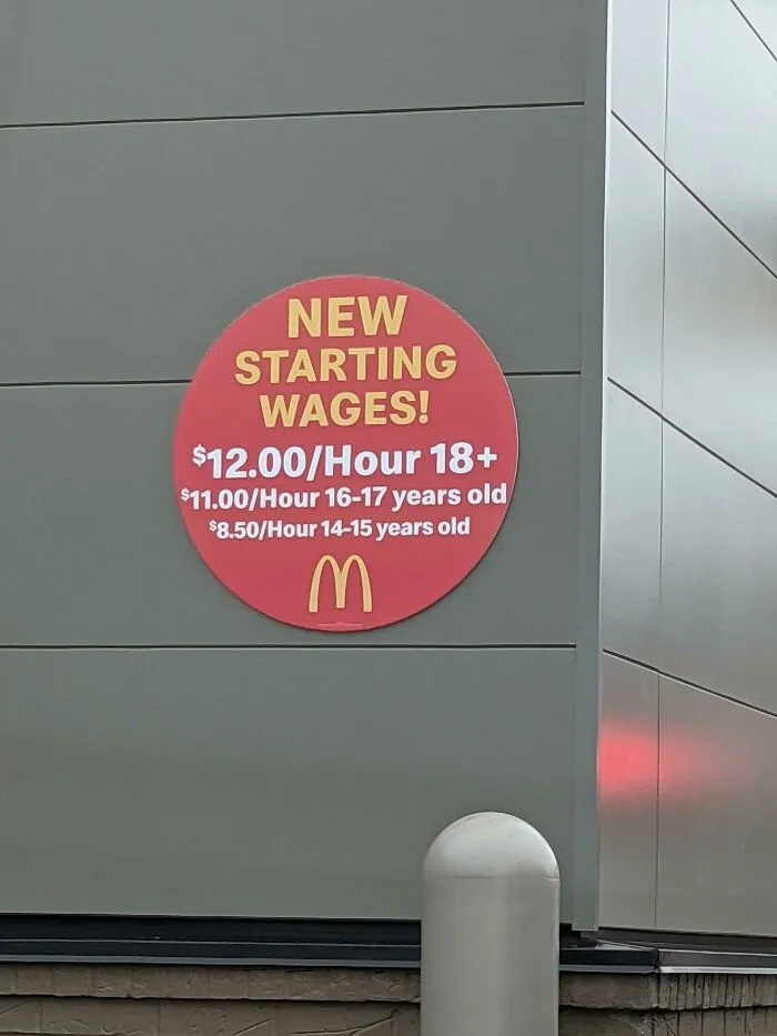 McDonalds starting wages sign showcasing different hourly pay rates, a reality of modern life in America.
