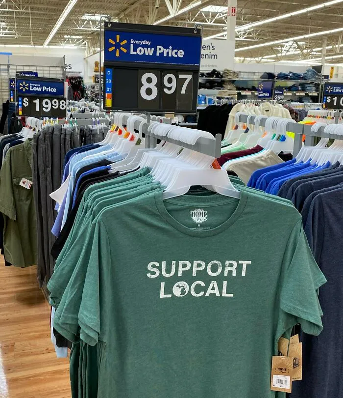 A rack of green Support Local t-shirts highlighting aspects of modern life in America.