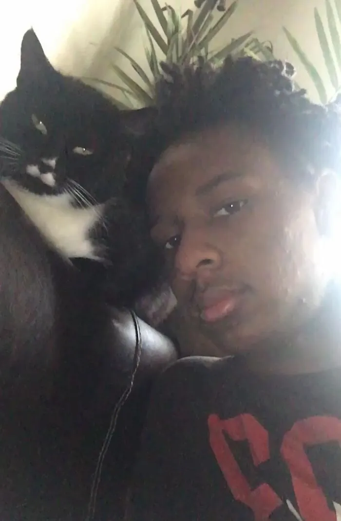 A teenage boy with his tuxedo cat, sharing their bond in a TikTok Trend showing life stories with pets.