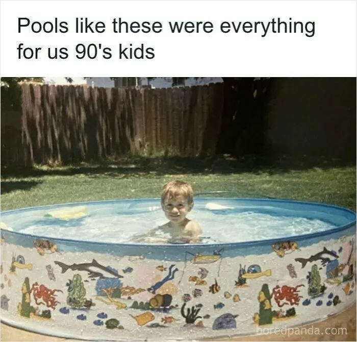 A young boy smiling in a small backyard plastic pool, evoking childhood memories for 90s kids