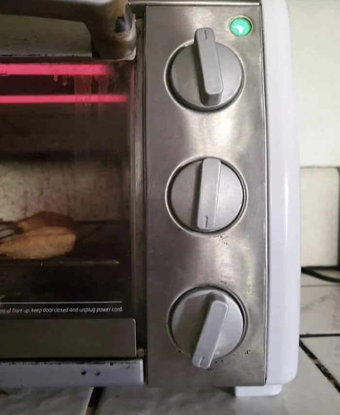 A dirty toaster oven heating food, depicting frustrating roommate stories in a shared apartment.