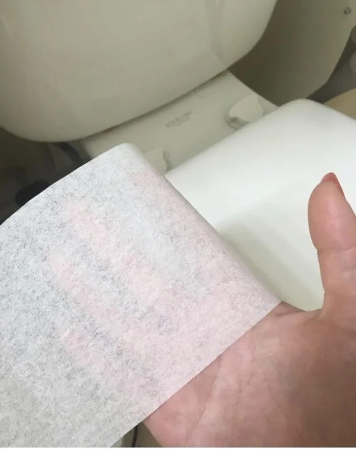 Extremely thin single-ply toilet paper held up to a hand, highlighting bad roommate stories