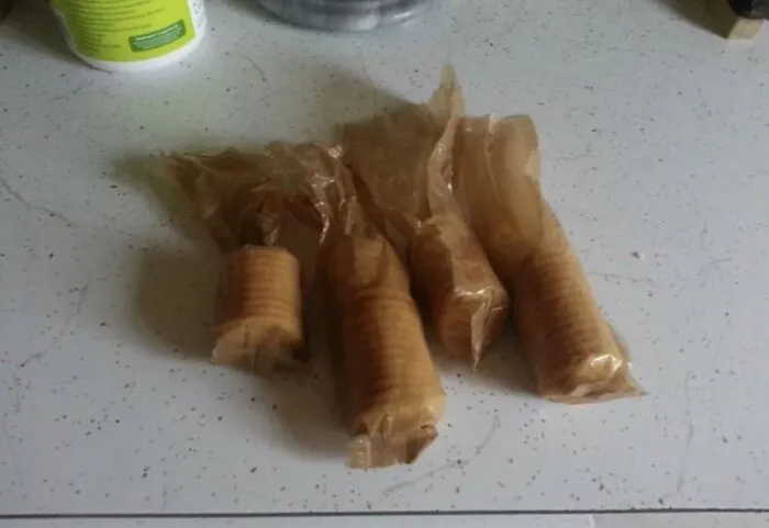 Four unwrapped packages of crackers left open on a kitchen counter