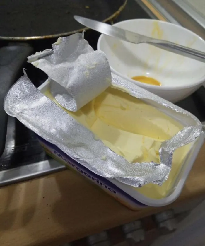 A poorly opened tub of margarine showcasing funny roommate stories about living together.