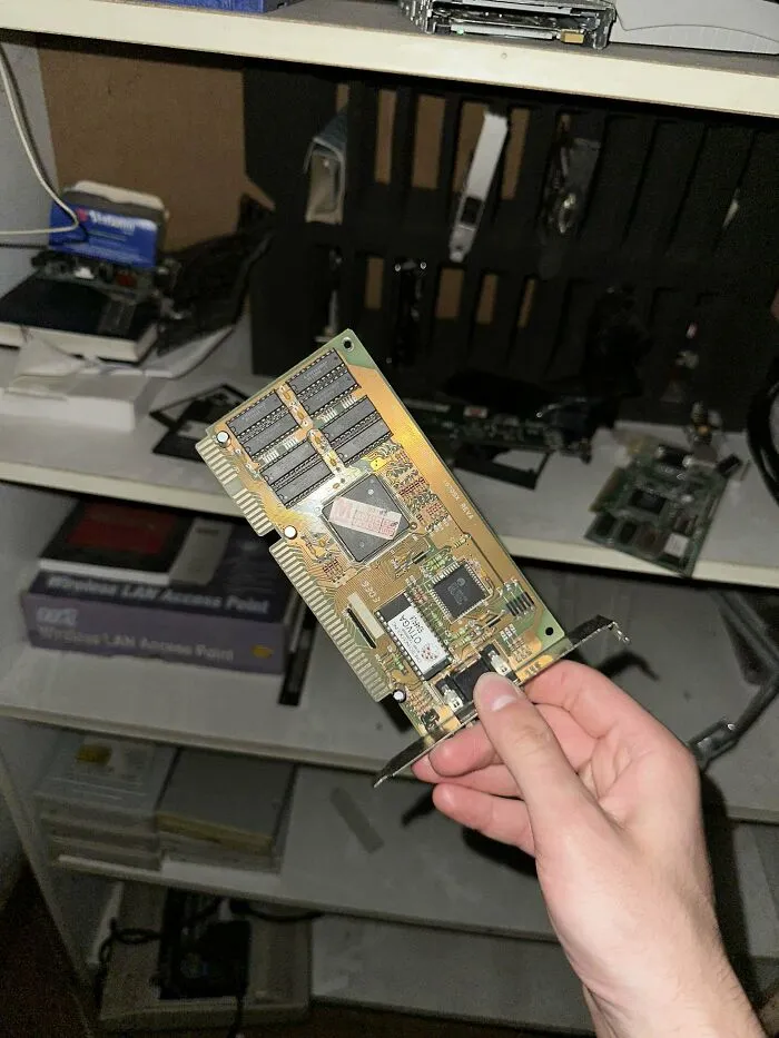A hand holding an old sound card from vintage tech finds